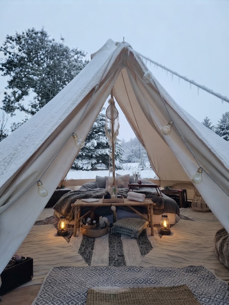 Bell tent-glampingtält med middagsdukning och ljusslingor i sydsvensk natur