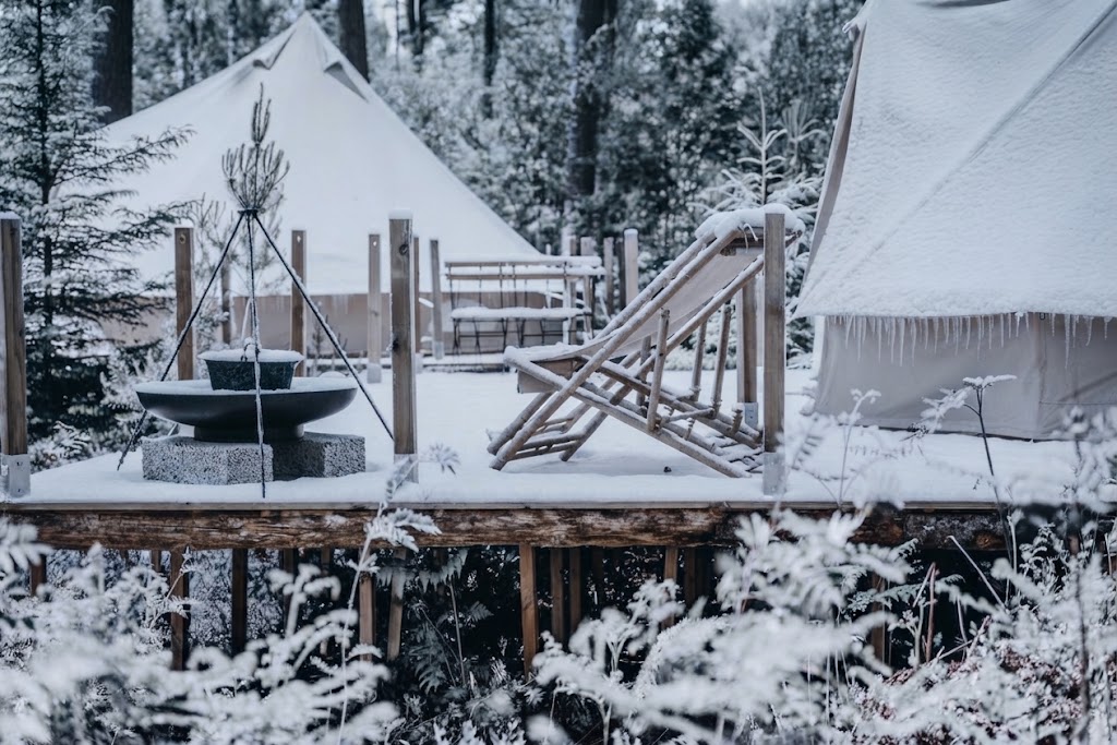 Glampingtält på trädäck i vintrig östgötsk natur nära Göta kanal