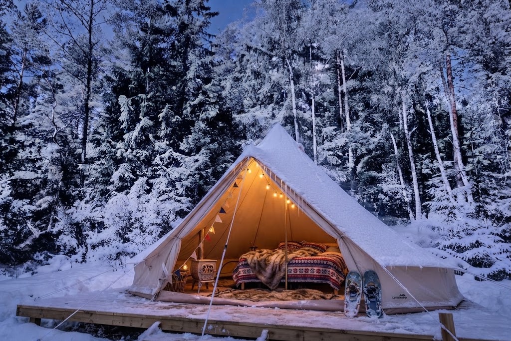 A-frame glampingstuga bland tallar i Stockholms skärgård med tänd brasa inomhus